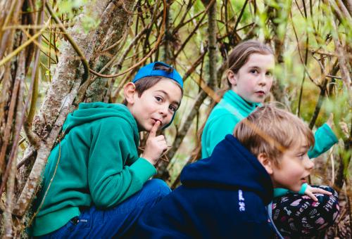 School children hiding in willow